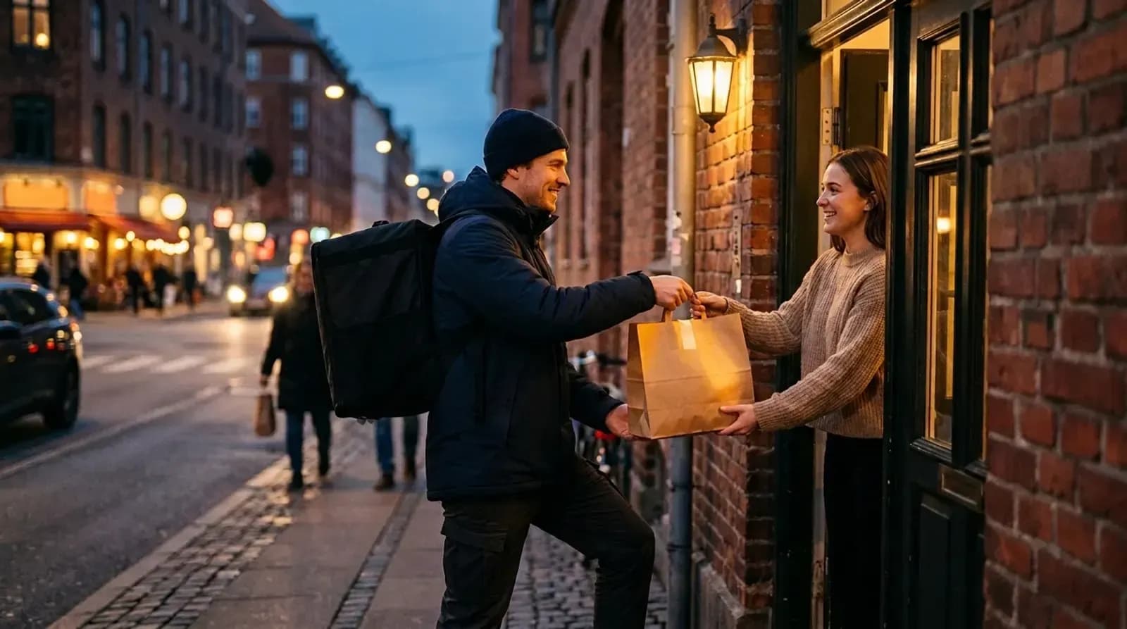 A food delivery rider handing a takeaway order to a customer at an apartment door
